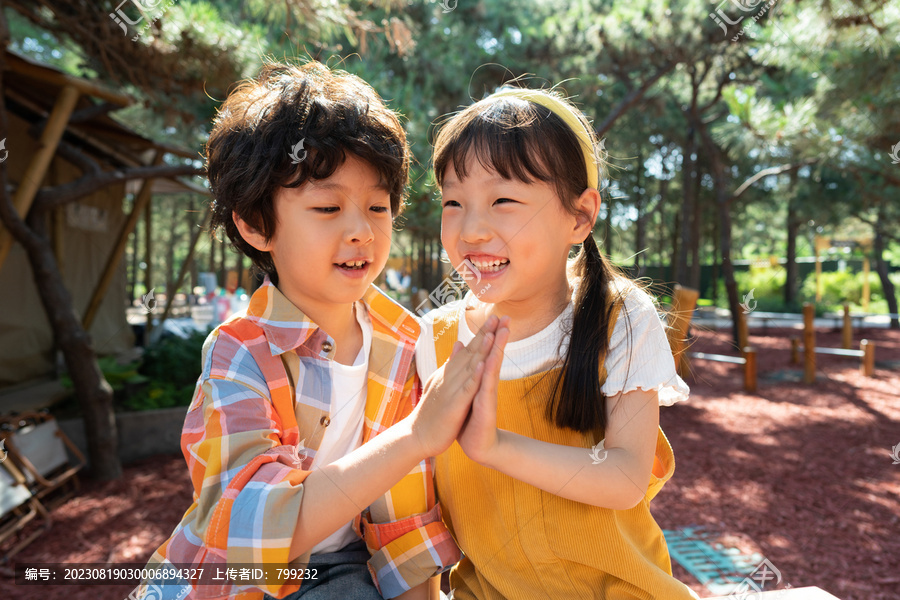 两个小孩子开心击掌庆祝