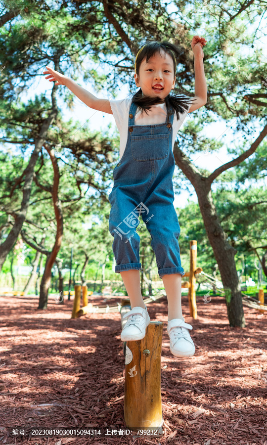 小女孩开心专注走独木桥