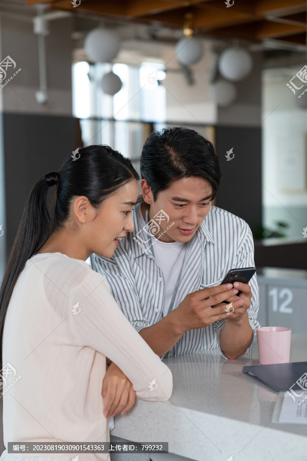 两个年轻人看手机开心畅聊