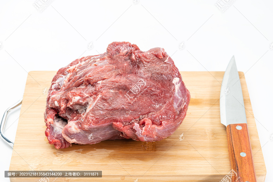 砧板上放着生牛肉与菜刀