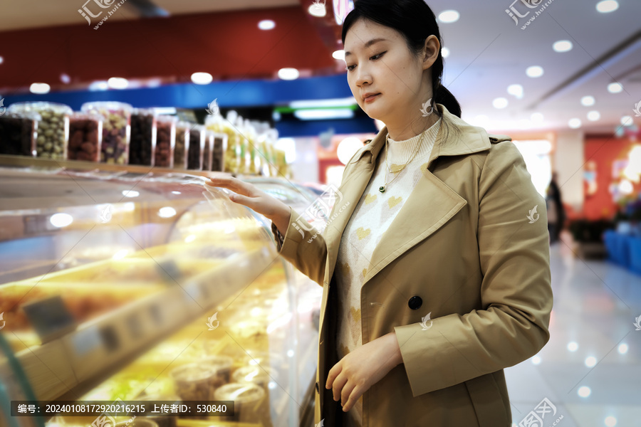 亚洲女性在超市货柜前选购商品