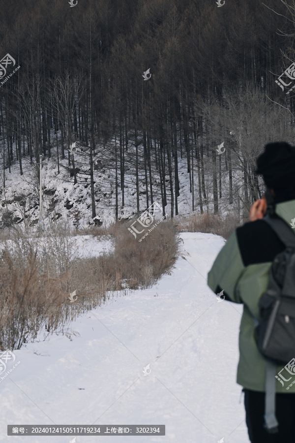 在山脚雪地道路上行走的人