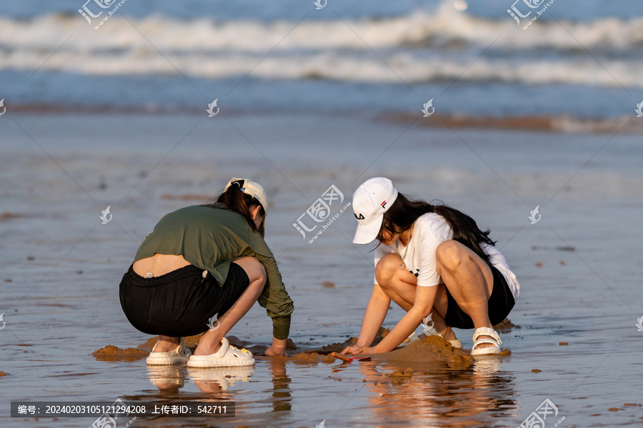 海滩上玩沙子的少女
