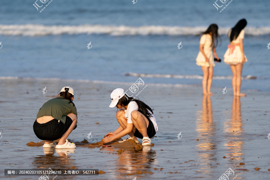 海滩上玩沙子的少女