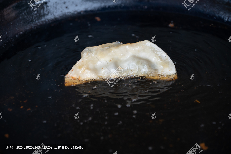 黑色煎锅里的一个煎饺常德锅饺