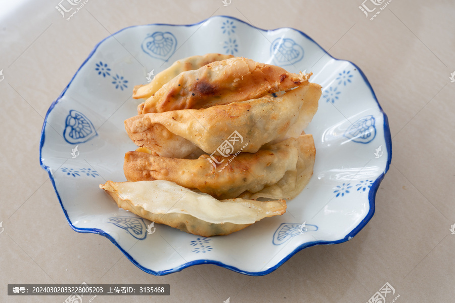 浅色桌面上一盘锅饺煎饺特写