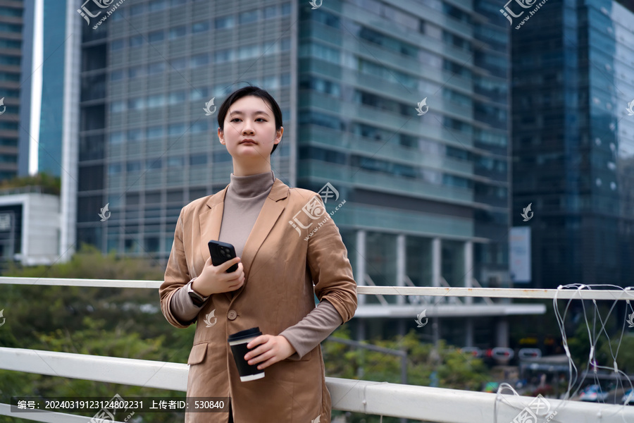 自信的女性在城市中使用智能手机
