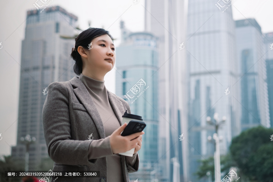 户外城市景观中收手机的自信女性