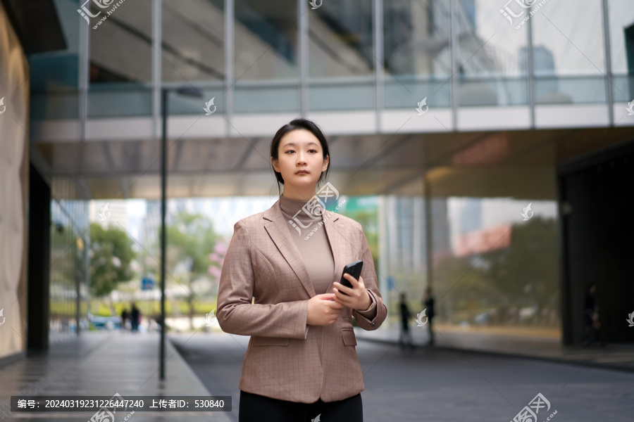 自信女子在城市里拿着智能手机