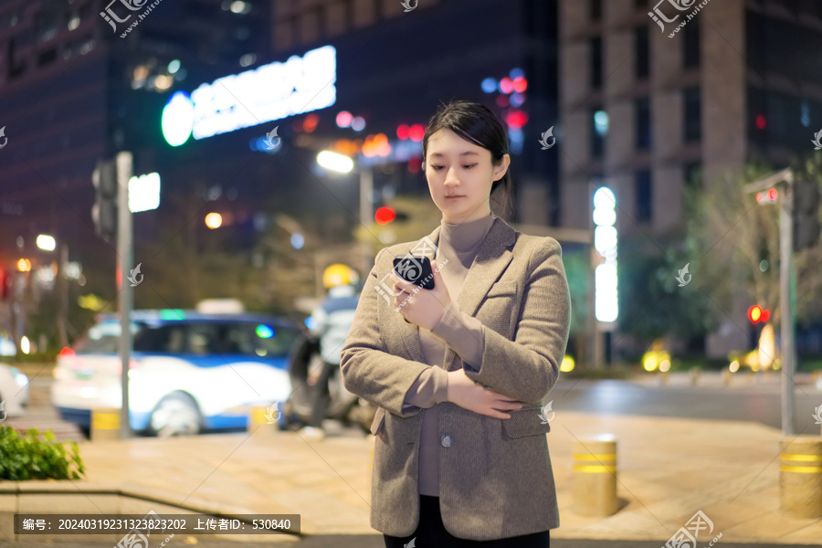 在傍晚街道上查看手机的职业女性