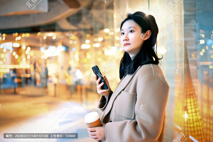 年轻女性手持手机在室内