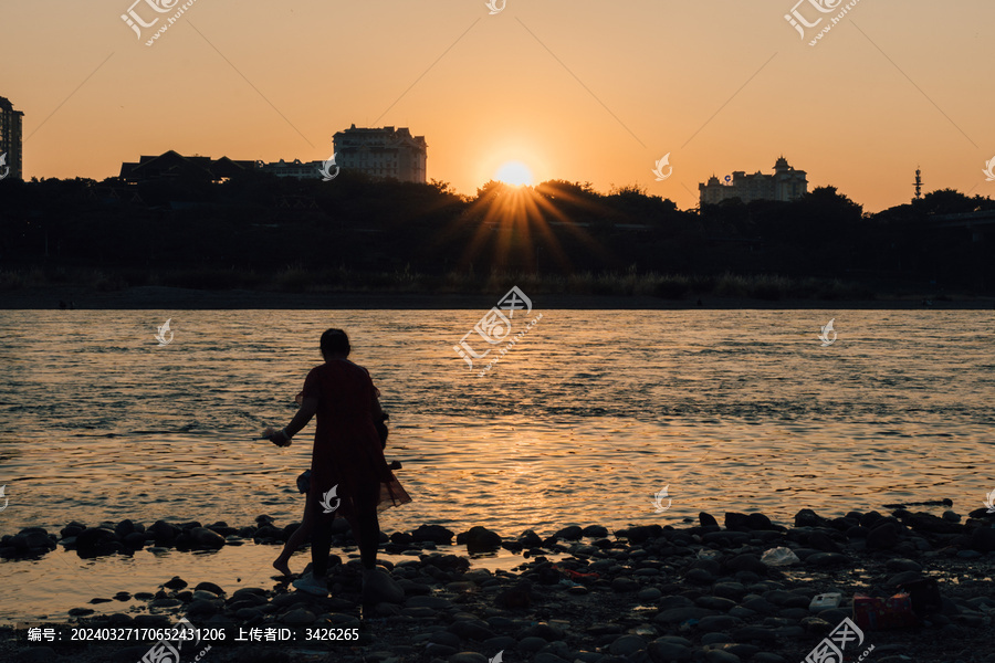 夕阳时在澜沧江边玩水人的剪影