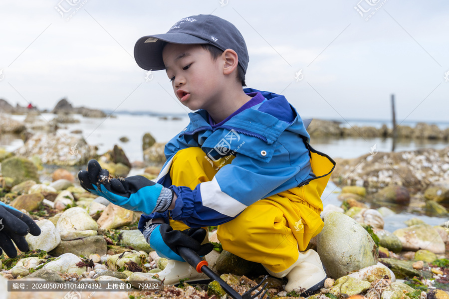 一个小男孩在海边赶海