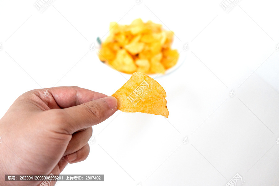 一盘白色彩绘碟子里装着一堆膨化薯片零食