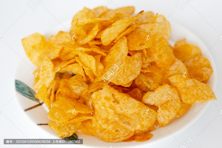 一盘白色彩绘碟子里装着一堆膨化薯片零食