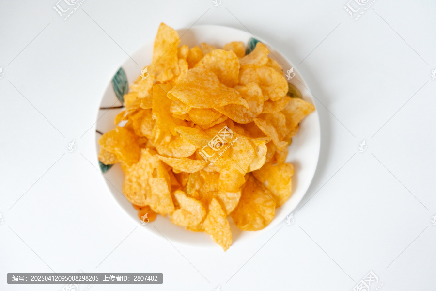 一盘白色彩绘碟子里装着一堆膨化薯片零食