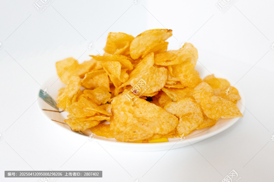 一盘白色彩绘碟子里装着一堆膨化薯片零食